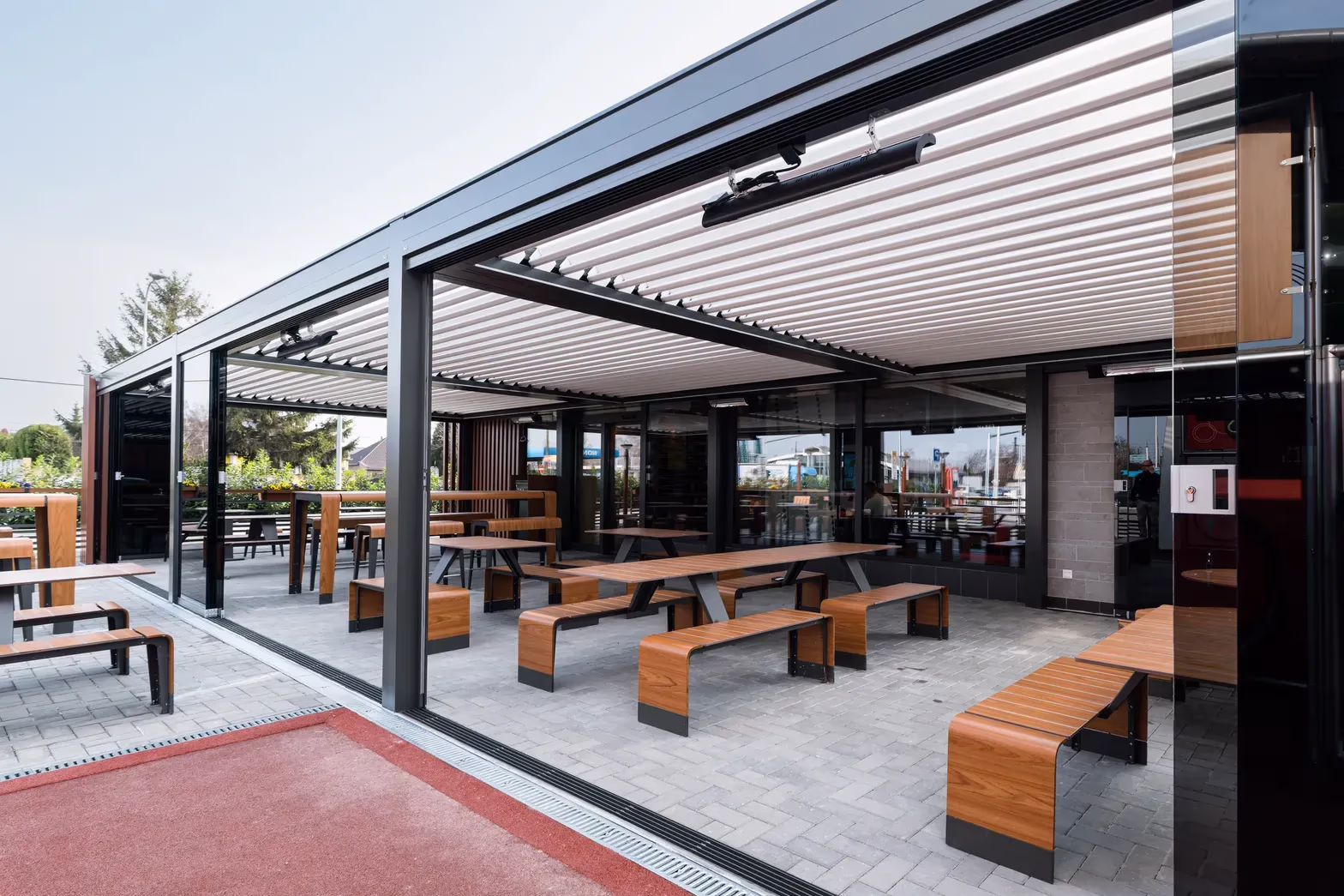 Infrared heater mounted under the roof of an aluminium pergola over a restaurant terrace