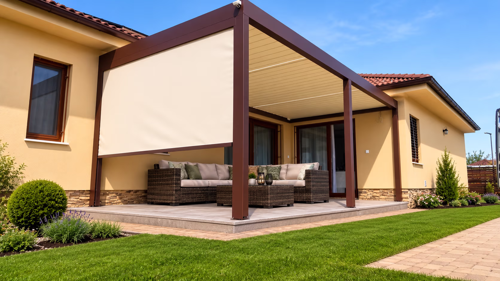 Brown bioclimatic pergola with closed louvres over a terrace beside a house