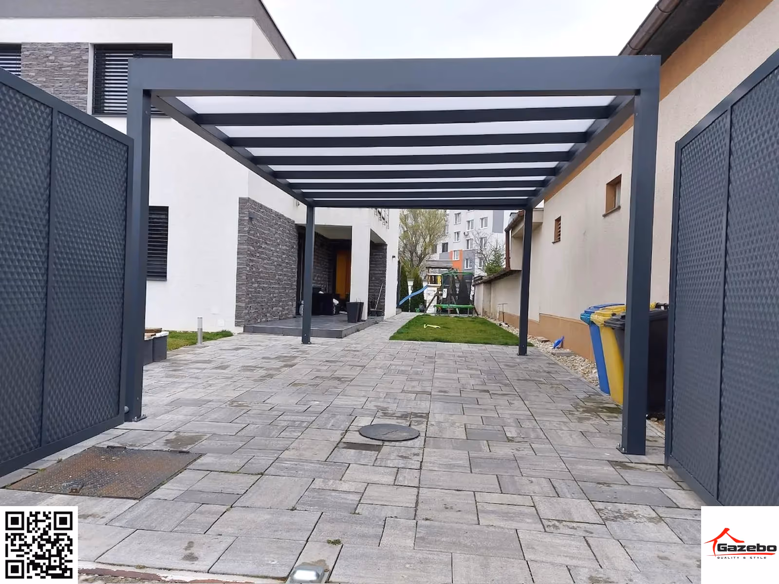 Aluminium carport at a driveway entrance flanked by two decorative gates
