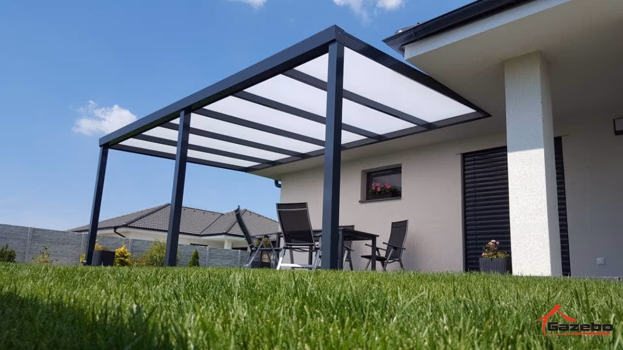 Anthracite Economic Class aluminium pergola beside a white house with terrace seating and a lawn