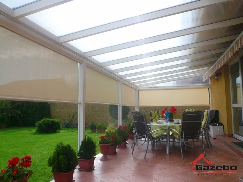 White Economic Class aluminium pergola over a terrace with a dining set in the garden