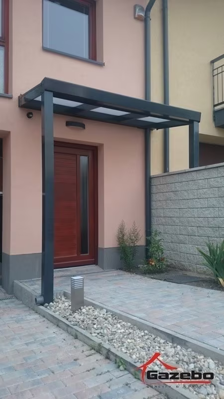 Anthracite Economic Class aluminium pergola as a canopy over the entrance of a pink house