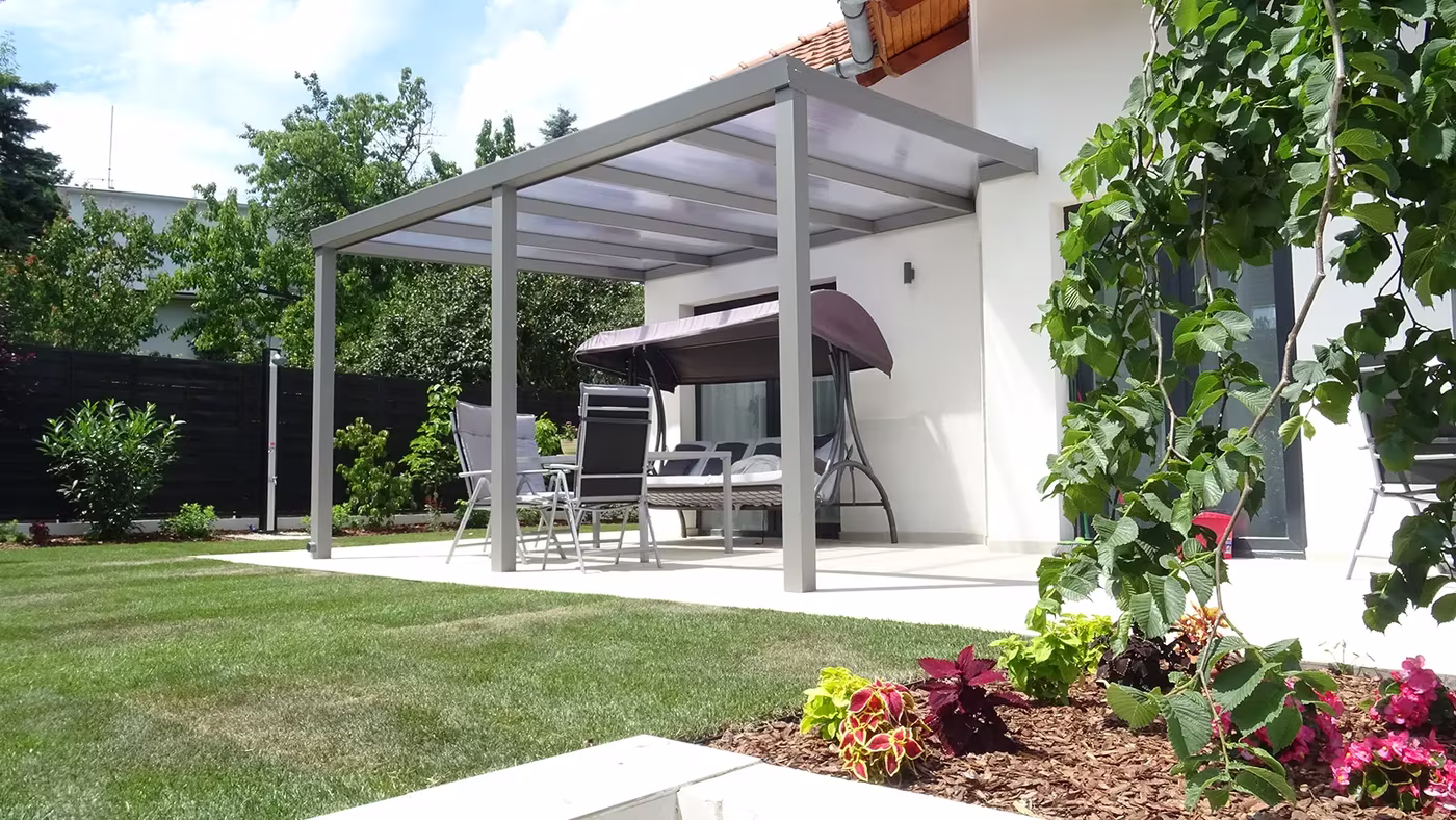 Anthracite Economic Class aluminium pergola over a paved area between houses with seating