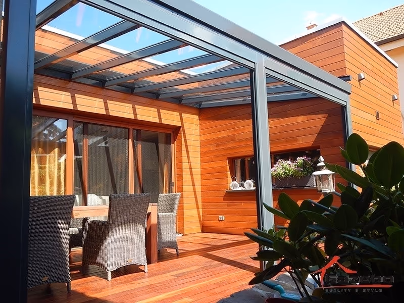 Top Class aluminium pergola beside a house with wood cladding