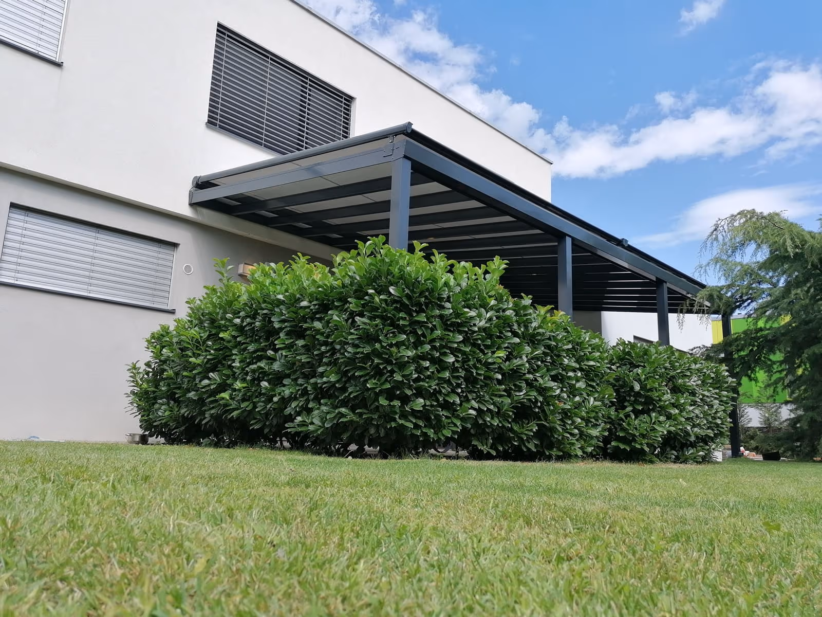 Top Class aluminium pergola beside large glass doors of the house