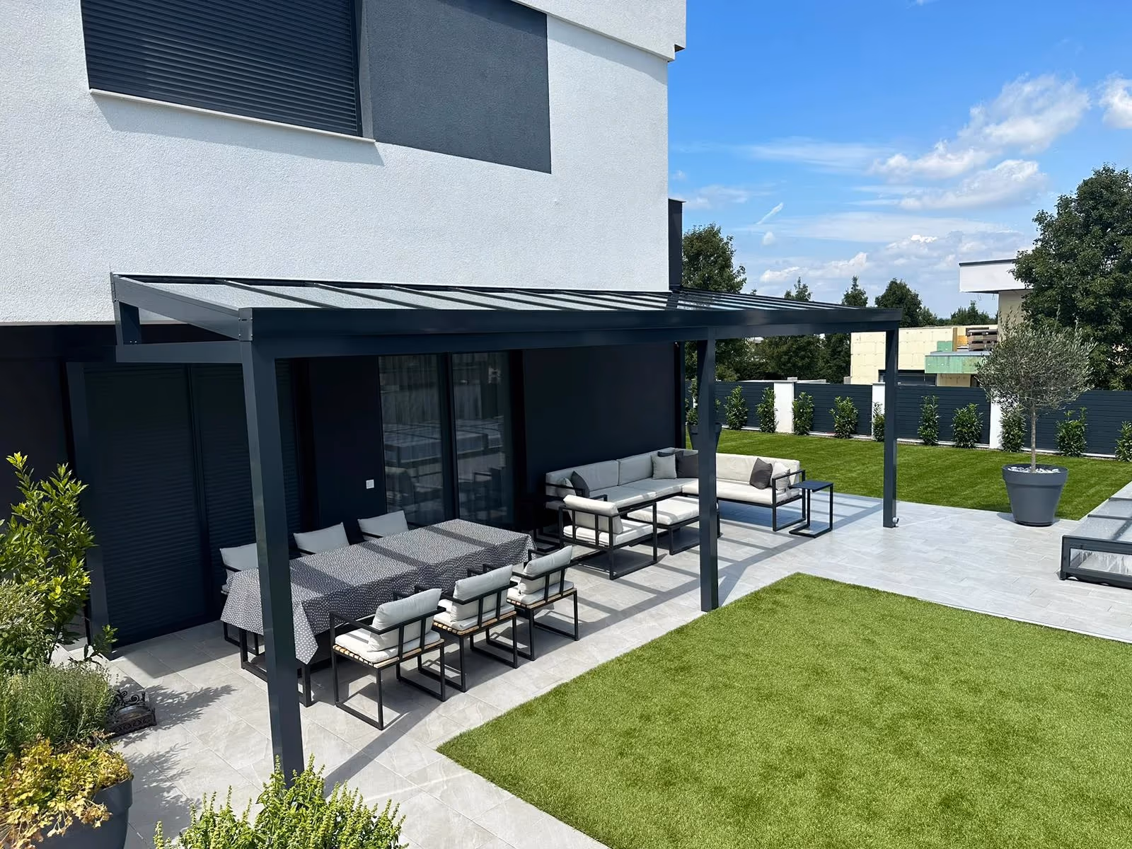 Top Class aluminium pergola with colourful cushions beside a modern house