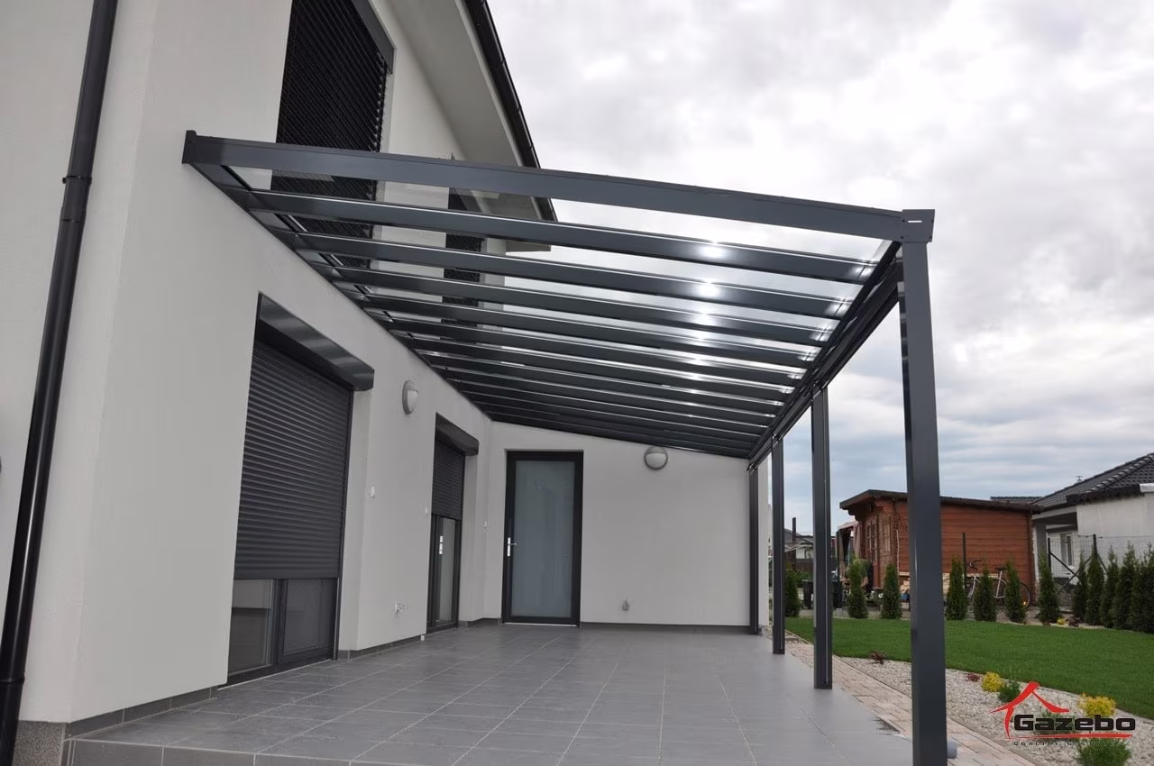Anthracite Top Class aluminium pergola over a paved terrace running along a house with roller shutters