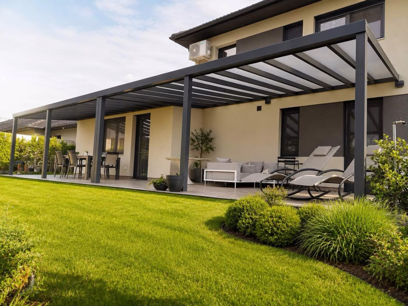Bespoke Top Class aluminium pergola with no width limit running along a family home with terrace seating