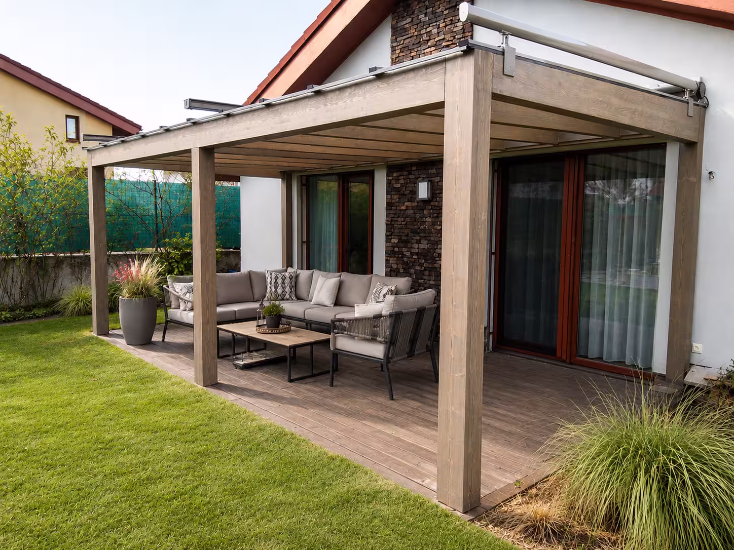 Milano wooden pergola against a stone façade with grey seating