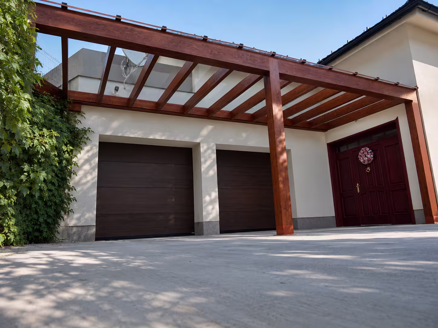 Milano wooden pergola with a glazed roof beside a garage