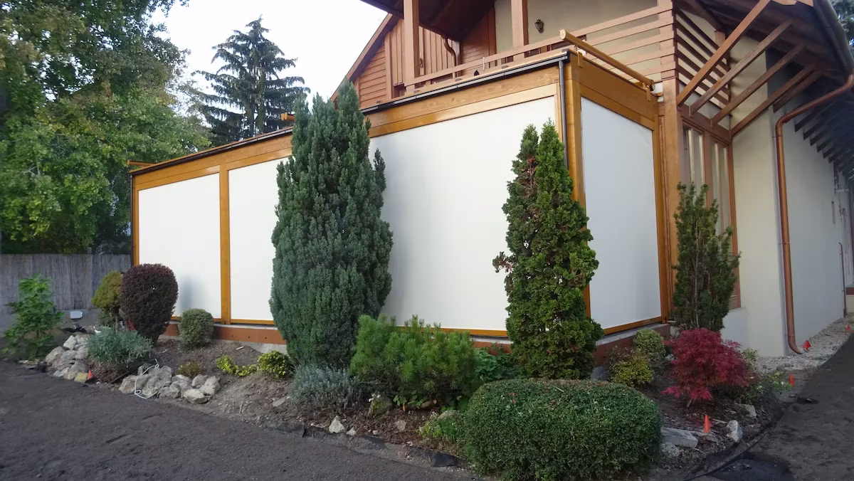 Milano wooden pergola with glazing and a landscaped garden