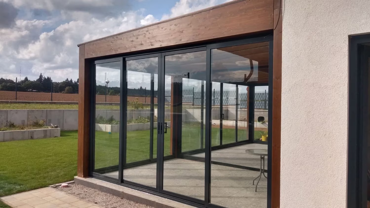 Milano wooden pergola with a glazed side wall and sliding doors