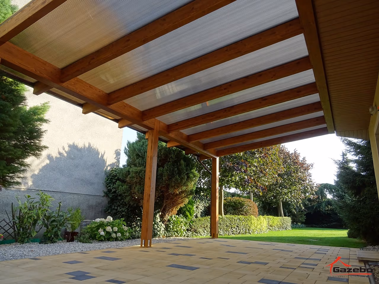 Cosy furnished corner beneath the Fenix wooden pergola with seating and flower pots